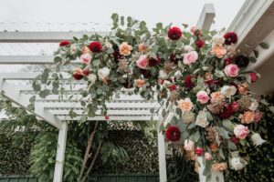 red rose peach carnation red dahlia wedding arch entrance